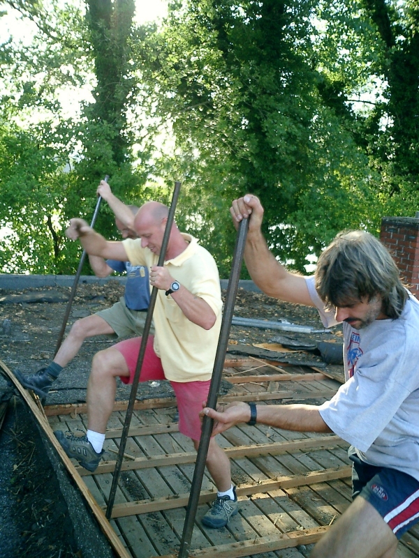 Das Flachdach wird Schicht um Schicht abgetragen
Mit viel Muskelkraft bauen hier Gerd Müller (verdeckt), Jürgen Keller und Bauausschuss Dietmar Knab die Holzlattung ab.
