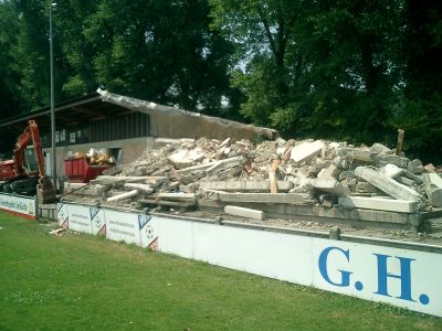 Bauabschnitt 1 wird bereits genutzt
Für den Spiel- und Trainingsbetrieb wird der 1. Bauabschnitt für die Saison 2003/04 bereits genutzt. Wie man sieht hat das alte Vereinsheim sein Funktionsangebot ganz eingestellt. Die Vereinsgaststätte wurde in der alten Hütte untergebracht, diese wird genutzt bis Oktober 2004. Nun geht es mit dem 2. Bauabschnitt los.
